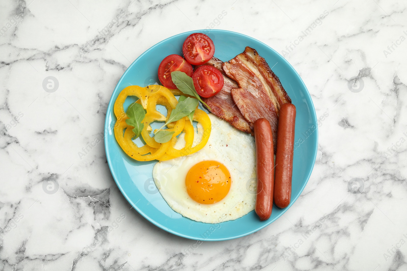 Photo of Breakfast with fried egg on white marble table, top view