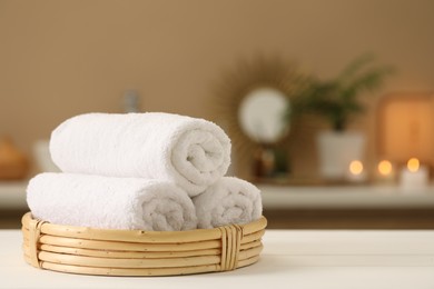 Photo of Spa composition. Rolled towels on white table indoors. Space for text