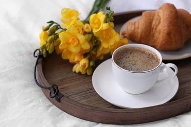 Photo of Morning coffee, croissant and flowers on bed