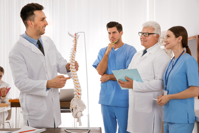 Photo of Medical students and professor studying human spine structure in classroom