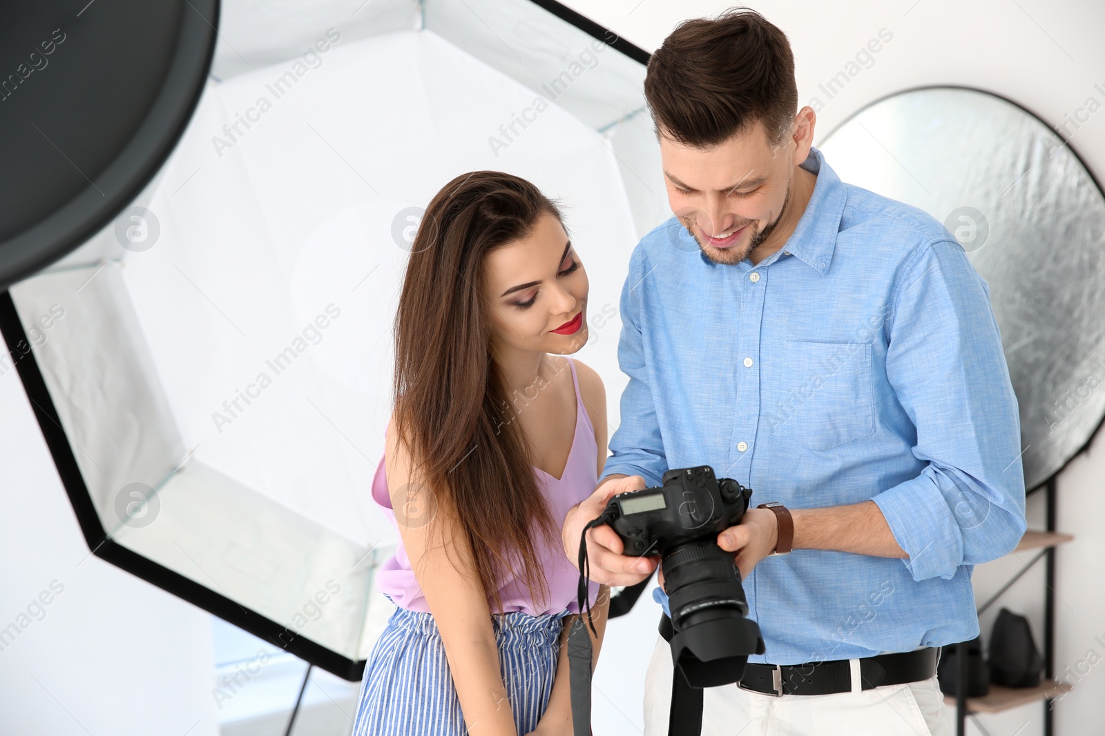 Photo of Beautiful young model with professional photographer in studio