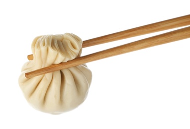 Chopsticks with tasty dumpling isolated on white