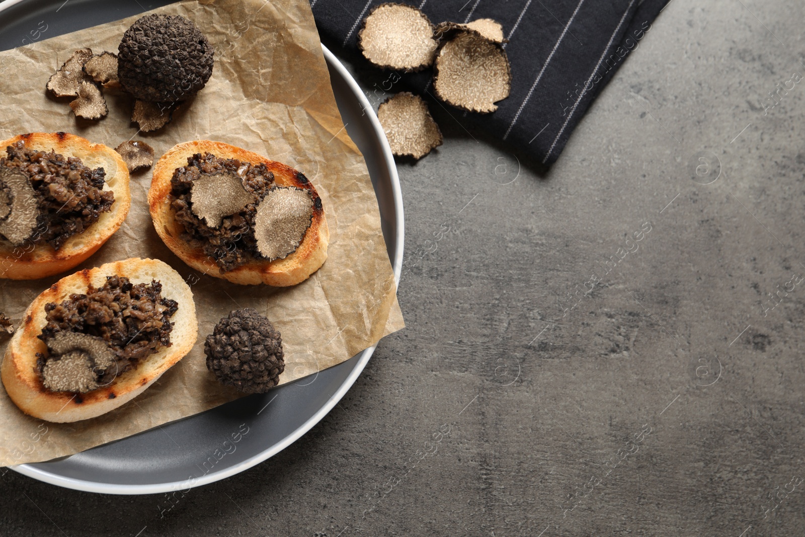 Photo of Delicious bruschettas with truffle sauce on grey table, flat lay. Space for text