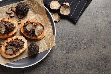 Photo of Delicious bruschettas with truffle sauce on grey table, flat lay. Space for text