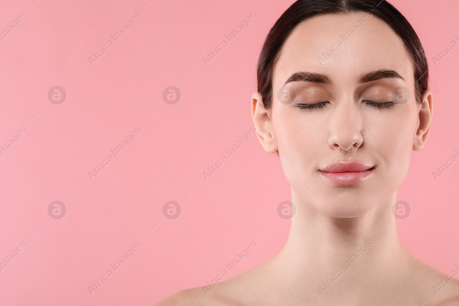 Photo of Portrait of beautiful young woman on pink background. Space for text