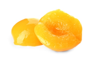 Halves of canned peach on white background