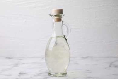 Vinegar in glass jug on white marble table