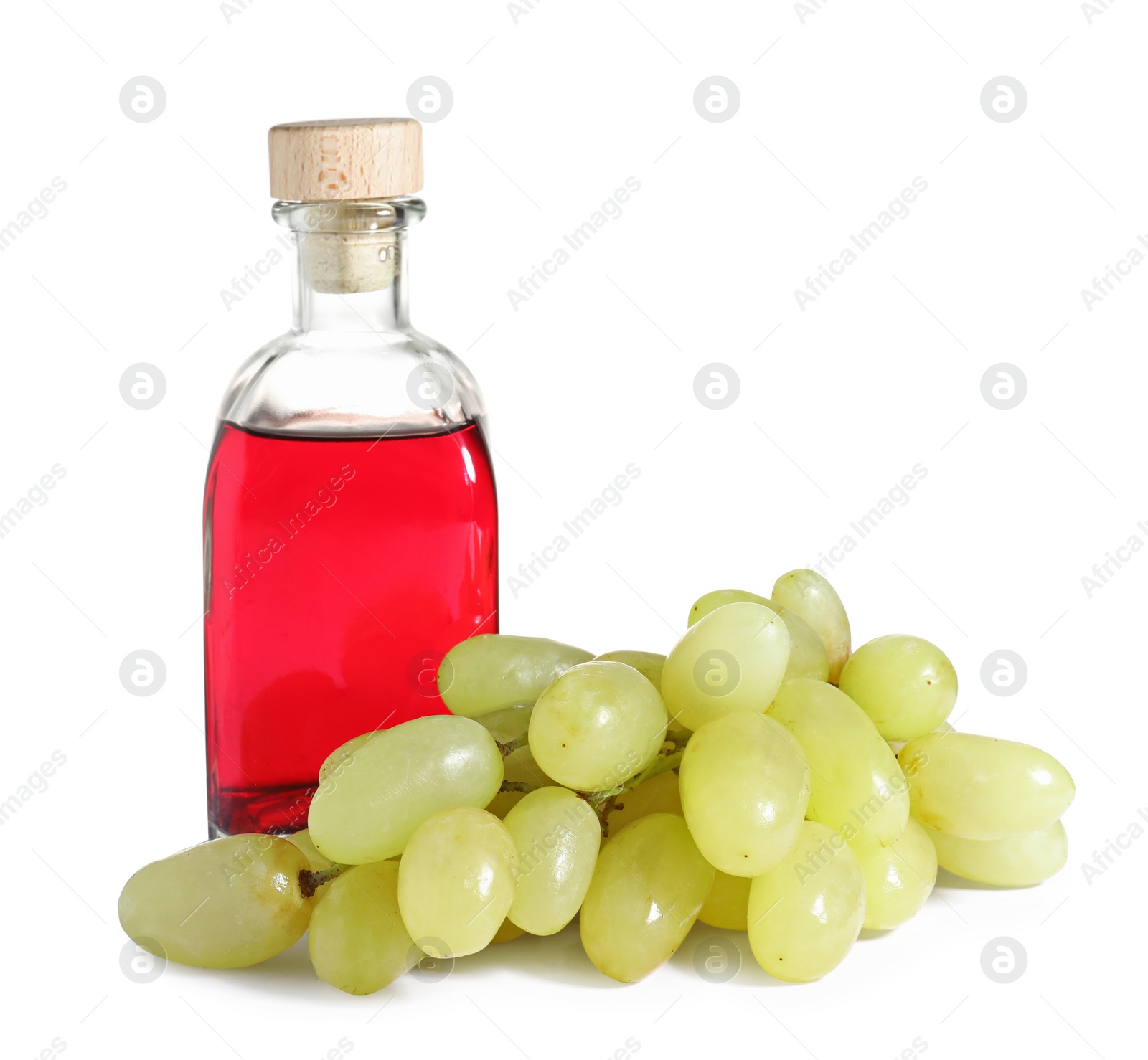 Photo of Glass bottle with wine vinegar and fresh grapes on white background