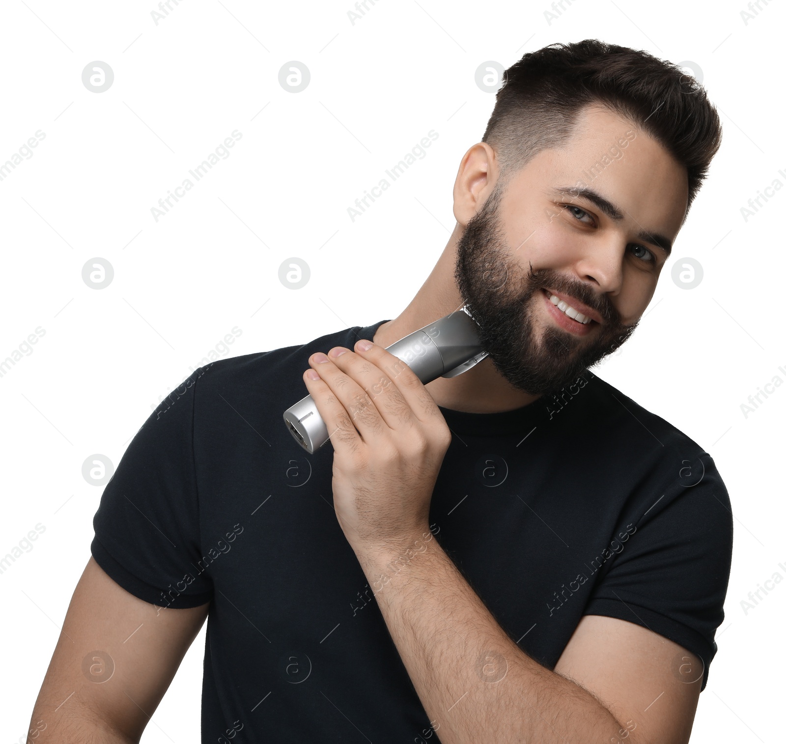 Photo of Handsome young man trimming beard on white background