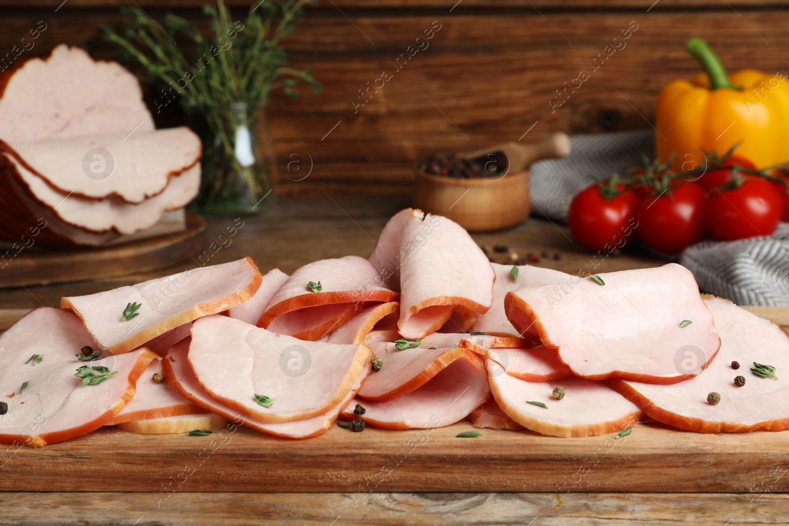 Photo of Delicious sliced ham with thyme and peppercorns on wooden table