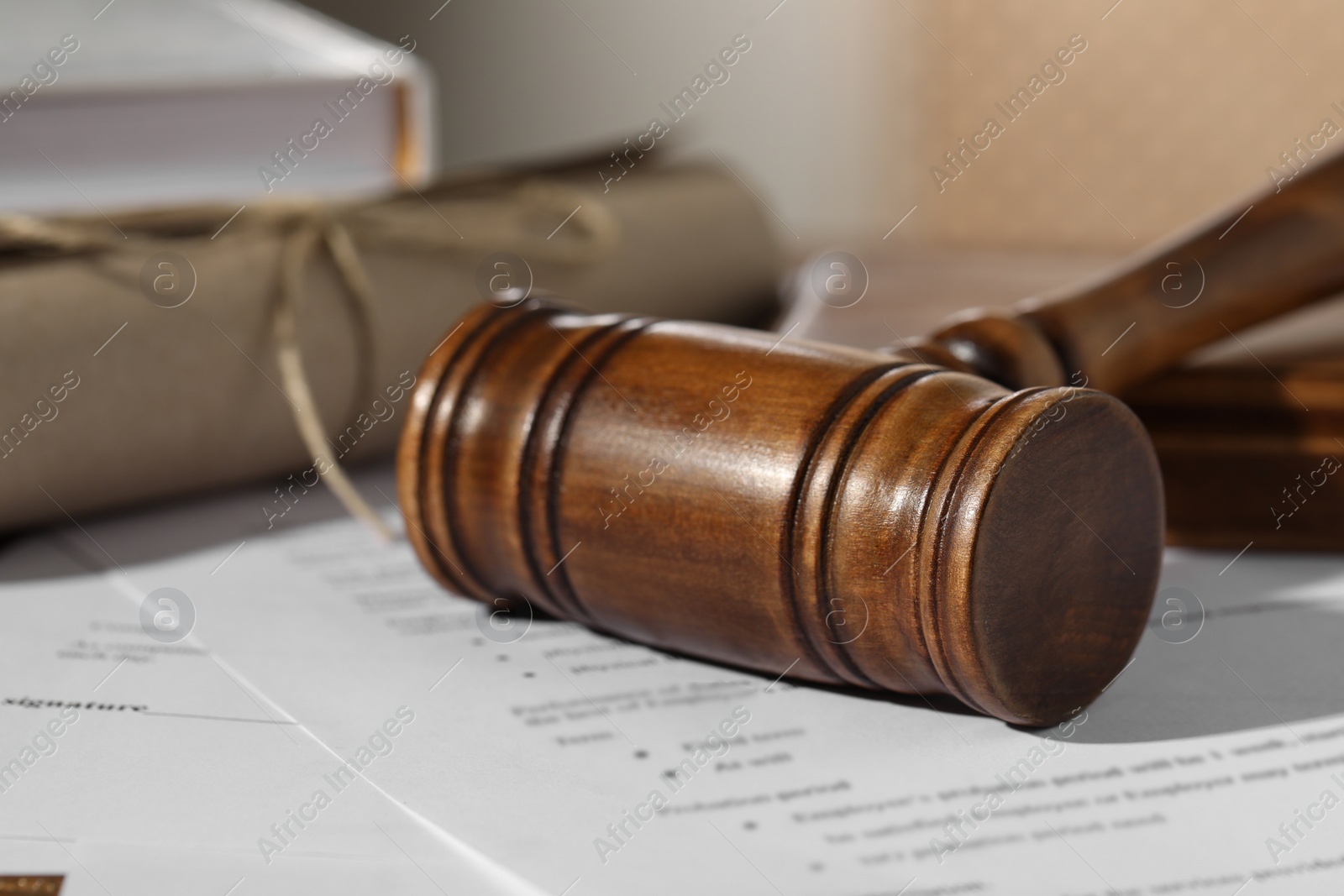 Photo of Notary contract. Wooden gavel and documents on table, closeup