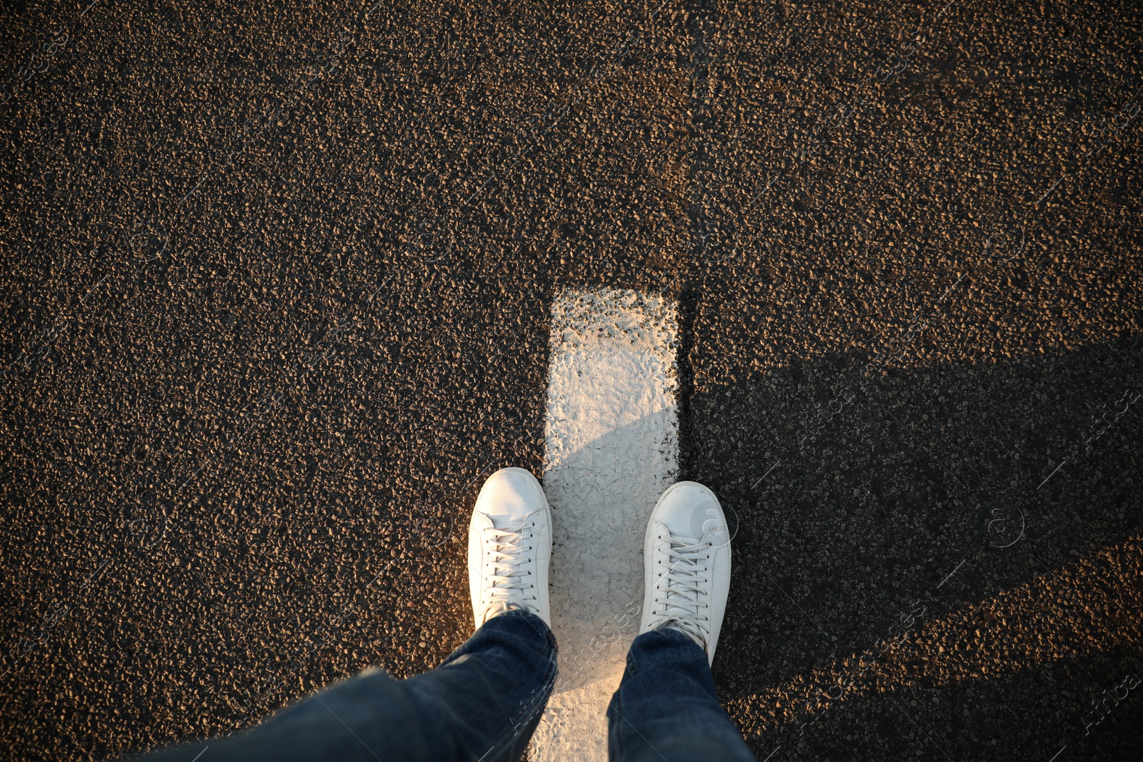 Photo of Top view of man standing on road with white line, space for text. Way concept