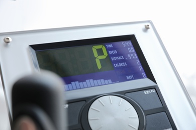 Control panel of modern elliptical machine cross trainer on white background, closeup