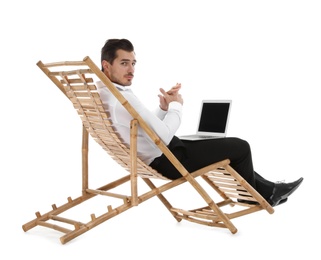 Photo of Young businessman with laptop on sun lounger against white background. Beach accessory