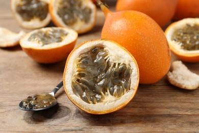 Photo of Delicious ripe granadillas on wooden table, closeup