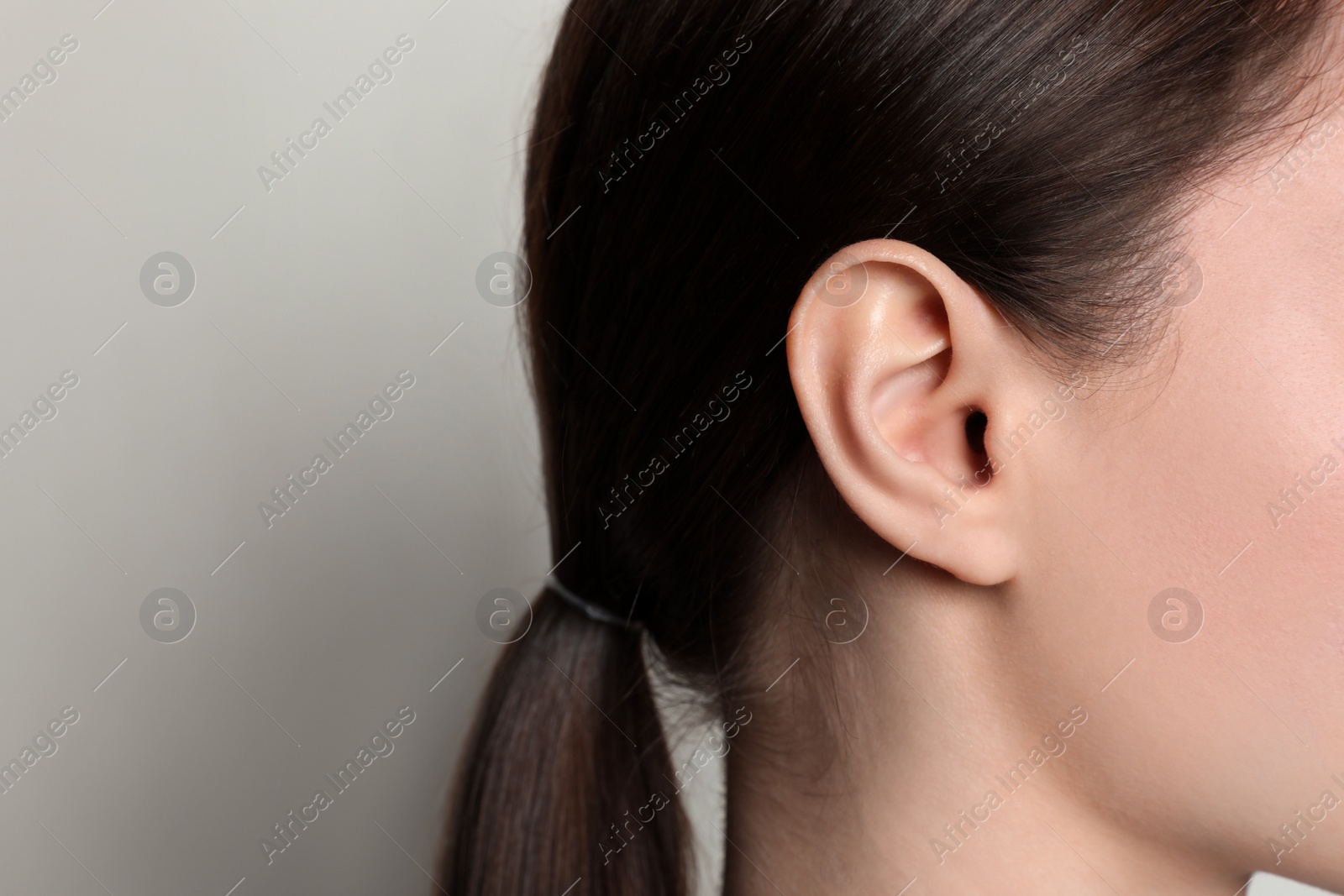 Photo of Woman on light background, closeup of ear. Space for text