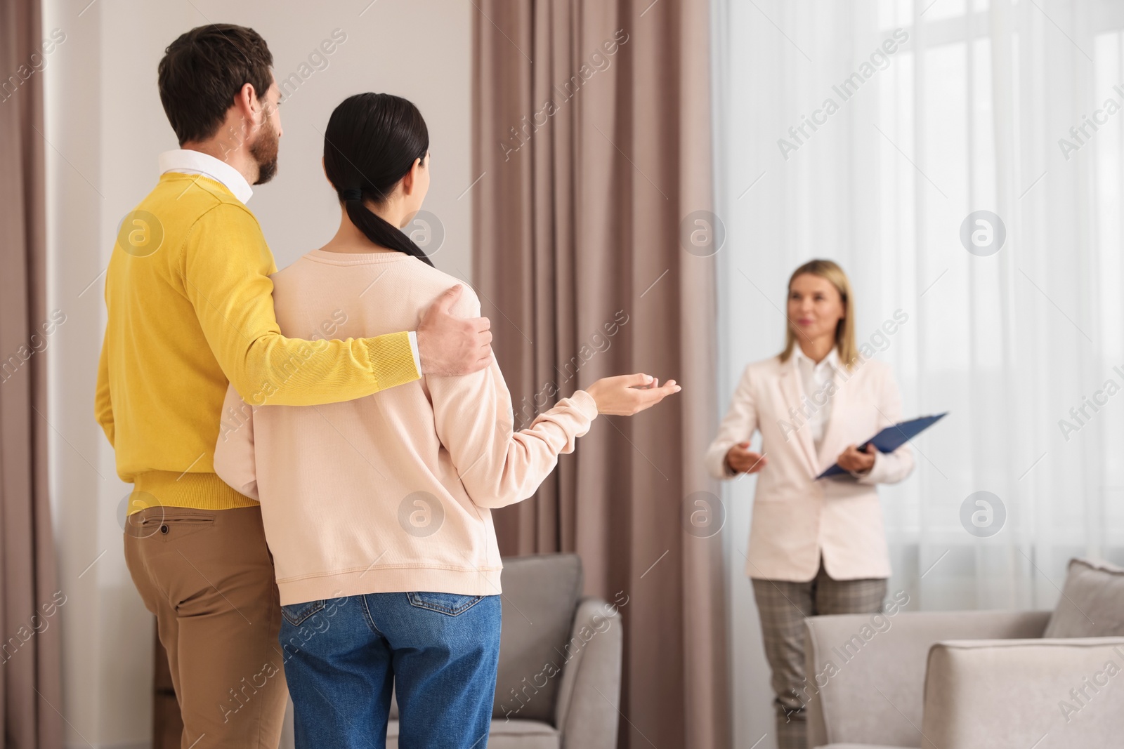 Photo of Real estate agent showing new apartment to couple