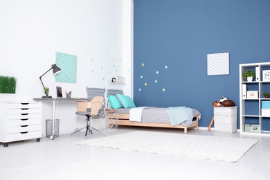 Photo of Modern child room interior with comfortable bed and desk