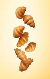 Crusty croissants falling on golden gradient background