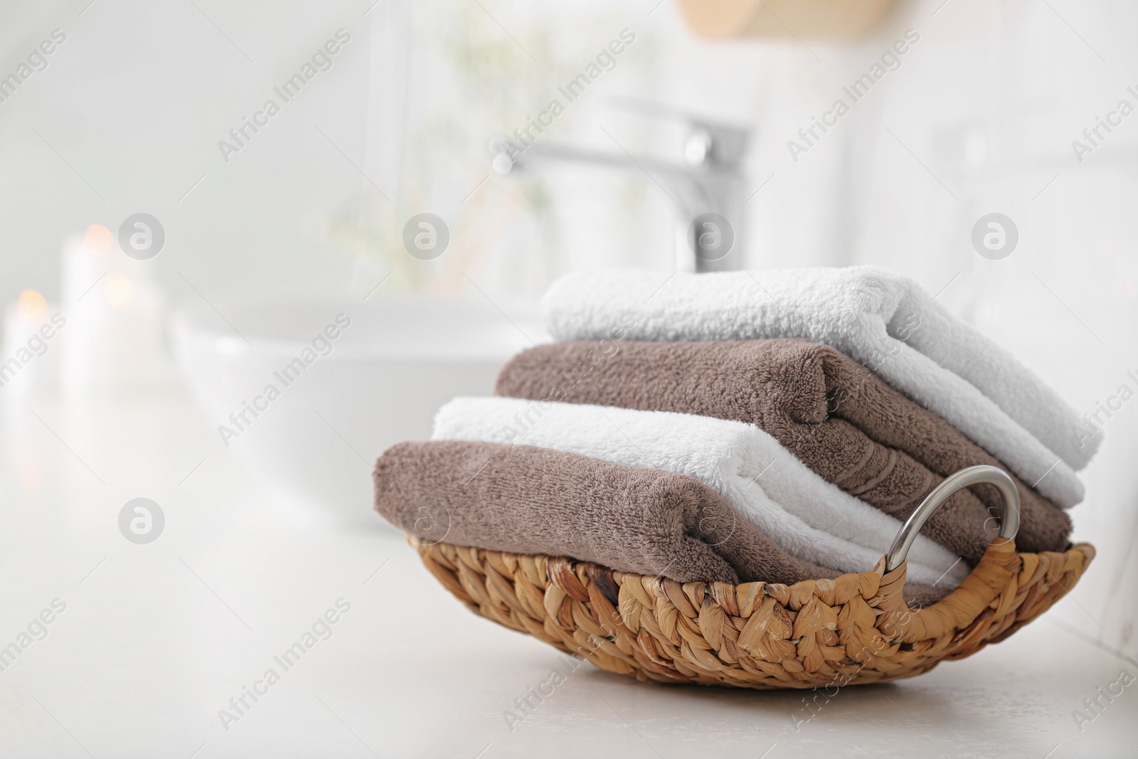 Photo of Basket with clean towels on counter in bathroom