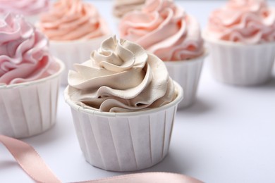 Photo of Many tasty cupcakes on white background, closeup