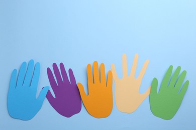 Photo of Equality concept. Different paper palms on light blue background, flat lay. Space for text