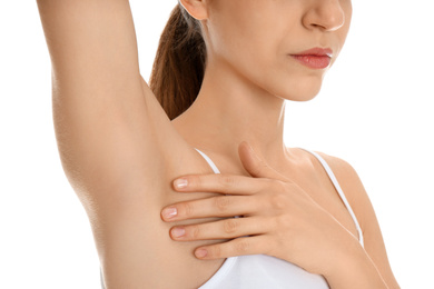 Young woman showing armpit with smooth clean skin on white background, closeup