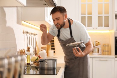Photo of Man tasting fresh bouillon in kitchen. Homemade recipe