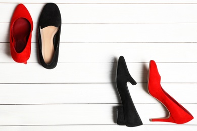 Photo of Flat lay composition with stylish shoes and space for text on wooden background