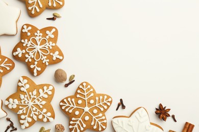 Photo of Tasty Christmas cookies with icing and spices on white background, flat lay. Space for text