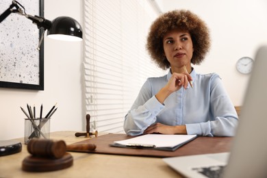 Photo of Notary with clipboard and pen at workplace in office