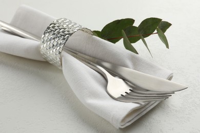 Photo of Stylish setting with cutlery and napkin on white textured table, closeup