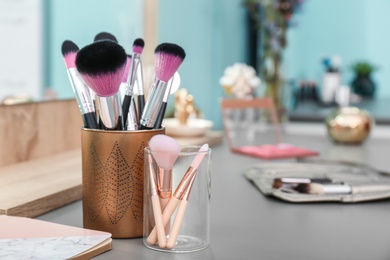 Photo of Brushes on dressing table in makeup room, closeup