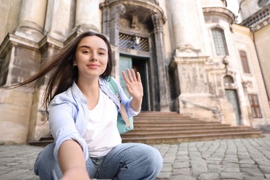 Photo of Beautiful travel blogger streaming outdoors, space for text