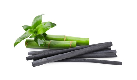 Photo of Fresh bamboo and charcoal on white background