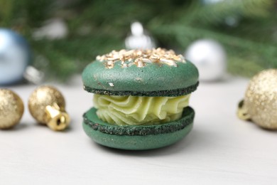 Decorated Christmas macaron and festive decor on white table, closeup