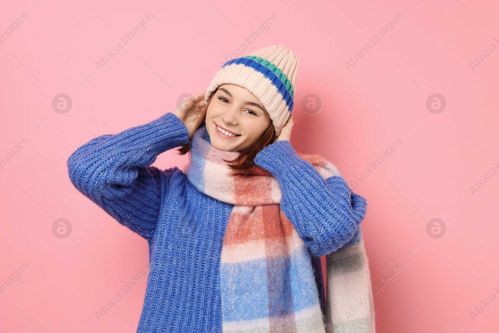 Photo of Beautiful woman in warm scarf and hat on pink background