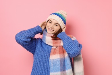 Photo of Beautiful woman in warm scarf and hat on pink background