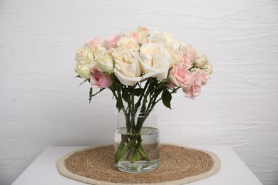 Photo of Beautiful rose flowers in vase on white table indoors