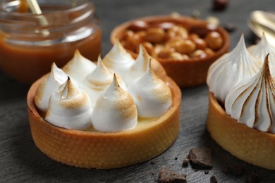 Photo of Different tartlets on dark grey table, closeup. Tasty dessert