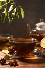 Photo of Aromatic tea with anise stars and lemon on wooden table