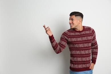 Photo of Handsome man in Christmas sweater on white background, space for text