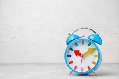 Photo of Alarm clock on table against light background. Time concept