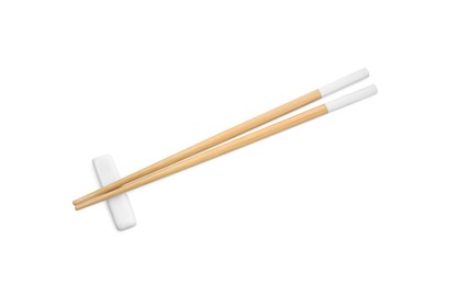 Photo of Pair of wooden chopsticks with rest isolated on white, top view