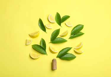 Photo of Flat lay composition with fresh green citrus leaves and lemon slices on yellow background
