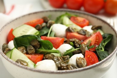 Photo of Salad with vegetables, capers and mozzarella in bowl, closeup