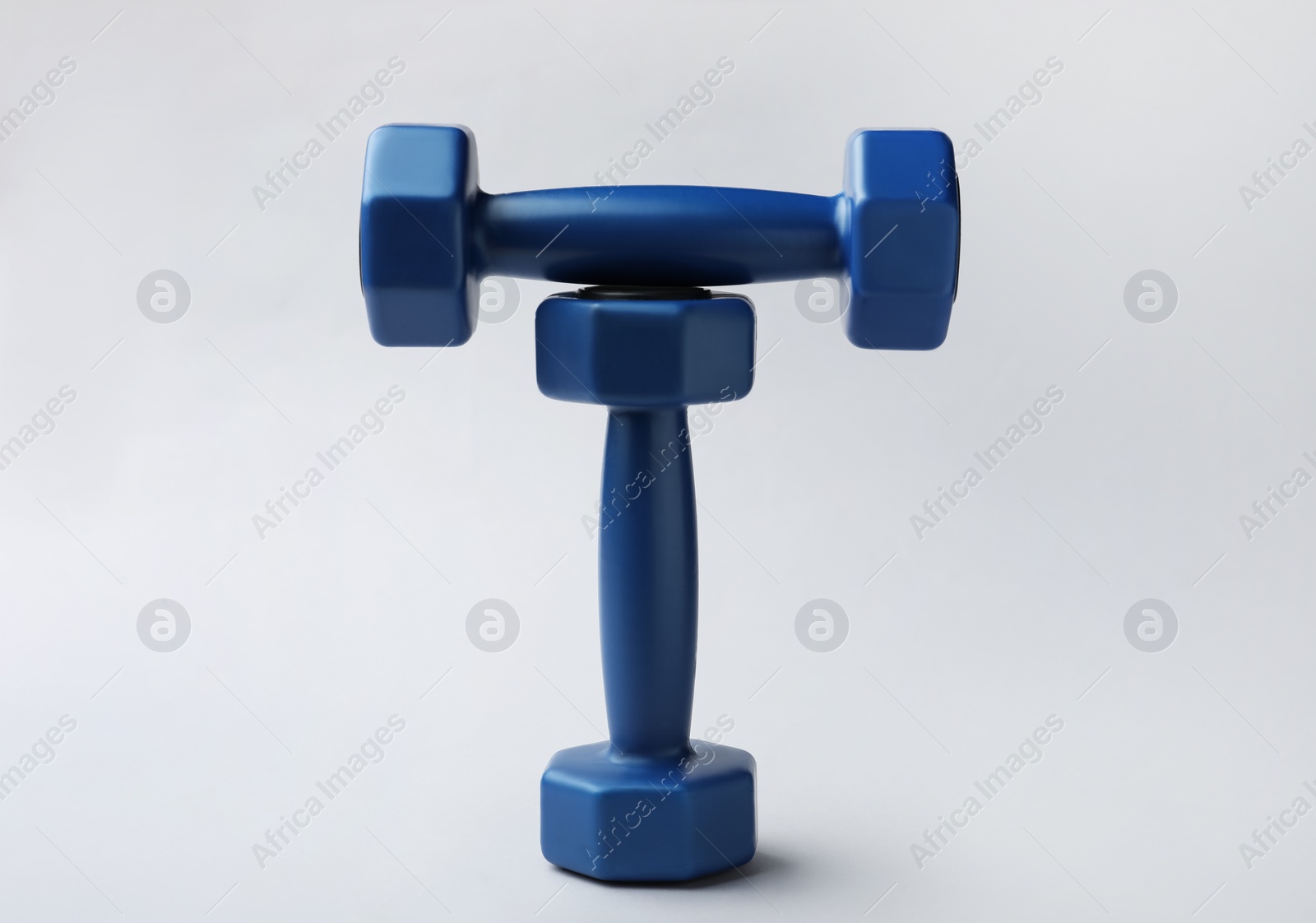 Photo of Two new blue vinyl dumbbells on light background