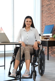 Portrait of young woman in wheelchair at workplace
