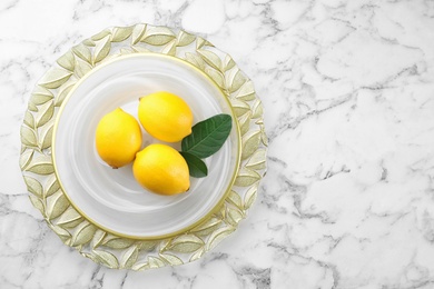 Fresh lemons and leaves on white marble table, top view. Space for table