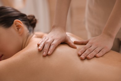 Photo of Woman receiving back massage in spa salon, closeup